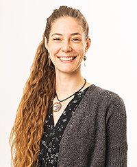 headshot of Anna Irish Burnett, a smiling woman with long curly light brown hair